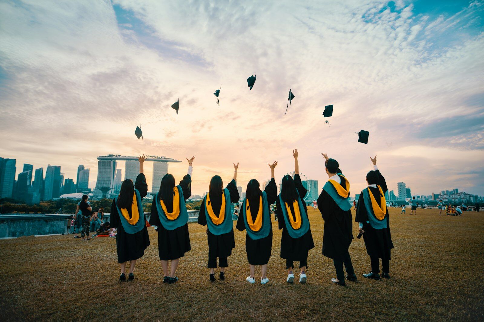 Graduating students celebrating against a city skyline, representing outcomes from AI-native learning