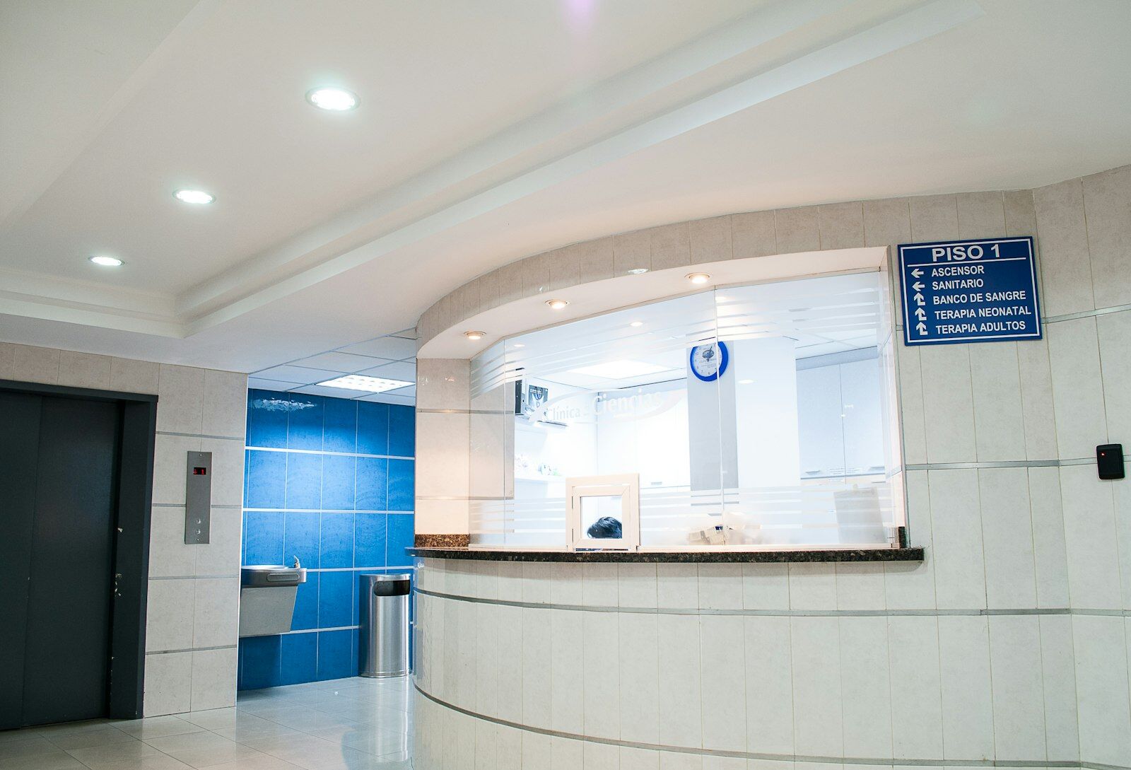 A clinician reviewing a patient record on a tablet in a hospital corridor